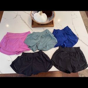5 pairs of size 4 lululemon shorts (2 black, 1 royal, 1 sage and 1 magenta) .